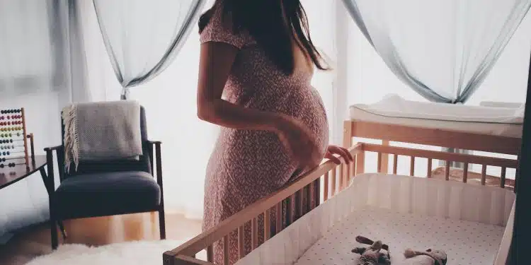 Une femme enceinte préparant la chambre de son futur bébé